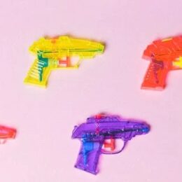 squirt guns on a pink background